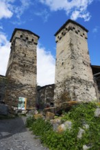 Two old stone towers under a blue sky with clouds, defensive towers, Ushguli, Ushguli, Shibiani