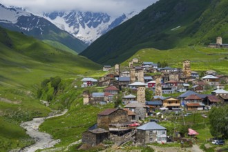 Picturesque village with many towers and houses in a green mountain valley, defensive towers,