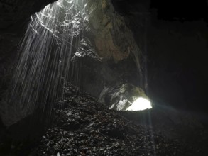 A ray of light falls into a dark cave and awakens a mysterious atmosphere, High Tatras, Poland