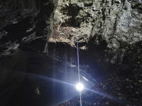 A bright ray of light falls into a dark and mysterious cave, High Tatras, Poland