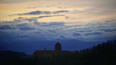 Castle silhouette against dramatic sunset sky, calm and mystical atmosphere, Rosenberg Fortress,
