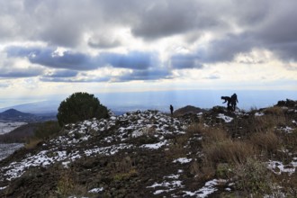 Barren volcanic landscape with remnants of snow, hikers, Etna, Etna, Catania, Sicily, Italy