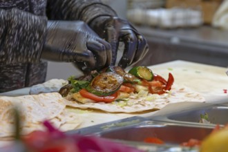 Preparation of falafel with fresh vegetables in a falafel stand in the pedestrian zone, Nuremberg,