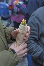 Hands holding a fresh falafel with vegetables, Nuremberg, Middle Franconia, Bavaria, Germany