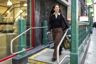 Young businesswoman with a confident smile walking up the stairs from a subway station entrance,