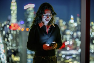 Young businesswoman with glasses smiling. Holding smartphone. And texting or browsing online during