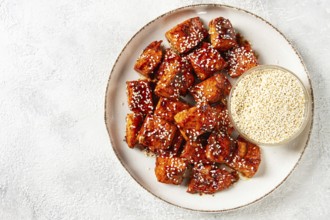 Fried pieces of salmon teriyaki with sesame seeds, top view
