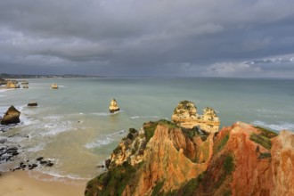 Rocky coast with storm cloud, Praia do Camilo, Lagos, Algarve, Portugal