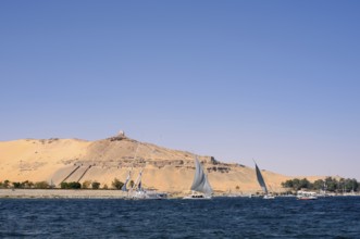 Qubbet el-Hawa with the rock tombs on the Nile, Aswan, Egypt