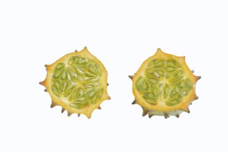 Horned cucumber, kiwano or horned melon (Cucumis metuliferus), sliced fruit on a white background,