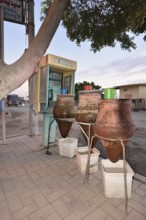 Telephone box and clay carafes with drinking water, Esna, Egypt