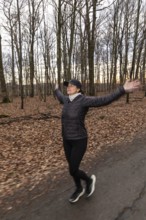 Woman jogging and doing sport exercise in winter nature. Germany