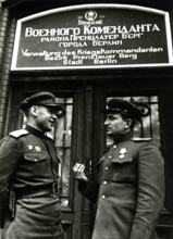 Two Soviet soldiers in front of the administration of the war commander for the district of