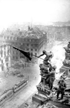 At the Berlin Reichstag, May 2, 1945, three Soviet soldiers fly the flag of the Soviet Union. The