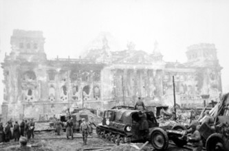Soviet soldiers with military equipment in front of the destroyed Reichstag, early May 1945,