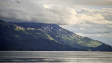 Dramatic mountain landscape with cloudy sky and calm lake in the foreground, Lake Ohrid, North
