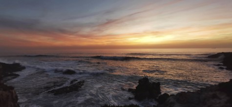 Sunset on the fishing trail over the sea with calm waves and colorful skies, Southwest Alentejo