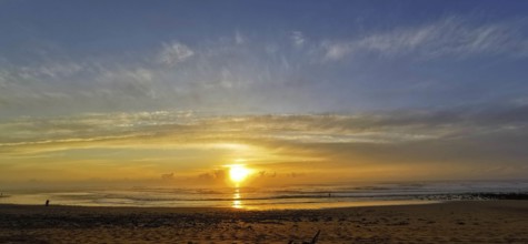 A calm sunset on the beach with cloudy sky and gentle sea, Sidi Ifni, Morocco