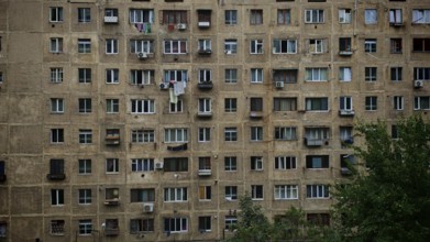 An old apartment block with lots of windows and balconies, surrounded by trees, Tbilisi, Georgia