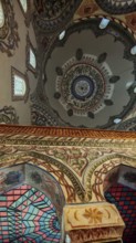 Richly decorated dome interior view with floral and geometric patterns in vivid colors, Prizren,
