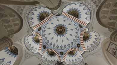Detailed view of a richly decorated dome with blue and gold ornaments in Islamic architecture,