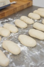 Several unbaked dough pieces for baguettes lie on a floured surface, bake rolls, Haselstaller Hof,