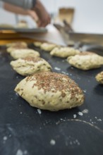 Unbaked dough with linseeds on a baking tray in a kitchen, baking rolls, Haselstaller Hof,