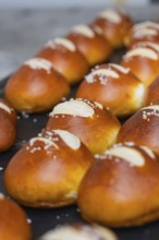 Fresh, golden brown pretzel rolls with salt streusel lie on a baking tray, bake rolls, Haselstaller