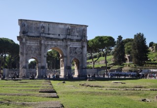 Arch of Constantine with tourists on sunny day, Lazio, Italy