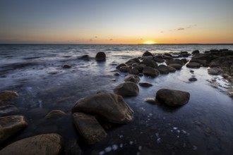 Rocks in the sea at sunset at Trönninge Stranden, Halmstad, Sweden