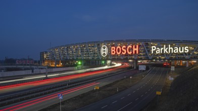 Traffic on the A8 motorway, blue hour, illuminated parking garage, Landesmesse Stuttgart, red-lit