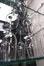 Showcase with elegant wine glasses on glass shelves