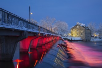 Illuminated Moulin Neuf water flow control dam and walkway over Des Mille-Iles river plus New Mill