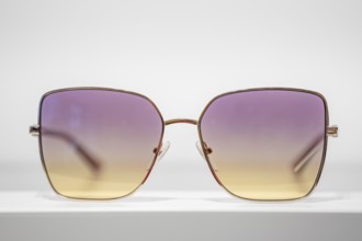 Sunglasses with purple-yellow gradient on white background, optician, Pforzheim