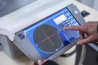 Finger points at the user interface of a medical device, optician, Pforzheim