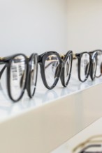 Several black eyeglass frames on a shelf in an optician's shop, optician, Pforzheim