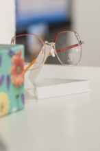 Close-up of stylish glasses next to a colorful floral pattern, optician, Pforzheim