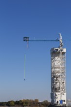 Montreal Bungee Tower with male bungee jumper in midair with his ankles tied to a long yellow