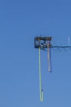 Montreal Bungee Tower installation with dangling long yellow elastic bungee jumping cord and woman