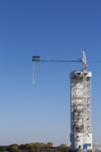 Montreal Bungee Tower with dangling long yellow elastic bungee jumping cord and man ready to jump,