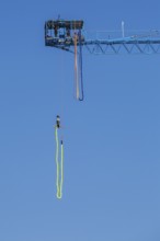 Montreal Bungee Tower installation with female bungee jumper in midair with her ankles tied to a