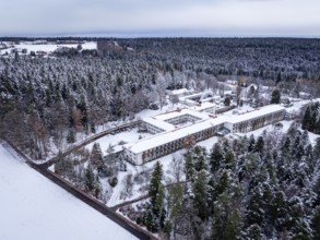 Snowy forest landscape with a large building in the middle, viewed from above, rehab clinic,