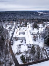 A snow-covered building in the middle of a wooded winter landscape mountain, Rehab Clinic,