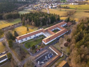 Building complex surrounded by fields in a rural village, from an aerial view, rehab clinic,