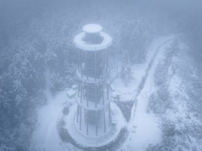 A bird's-eye view of an observation tower stands in a foggy winter landscape, Himmelsglück