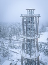 An observation tower towers over snow-covered forests in a foggy winter landscape, Himmelsglück