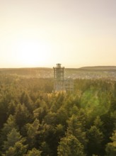 Wooded landscape with a panoramic tower in the distance at sunset, Himmelsglück observation tower