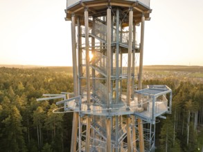 Metal observation tower at sunset surrounded by thick forests, Himmelsglück observation tower with