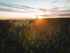 Sunset over a large forest with visible observation tower, Himmelsglück observation tower with