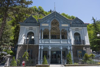 Magnificent historical architecture with an ornate blue veranda nestled in green nature, old villa